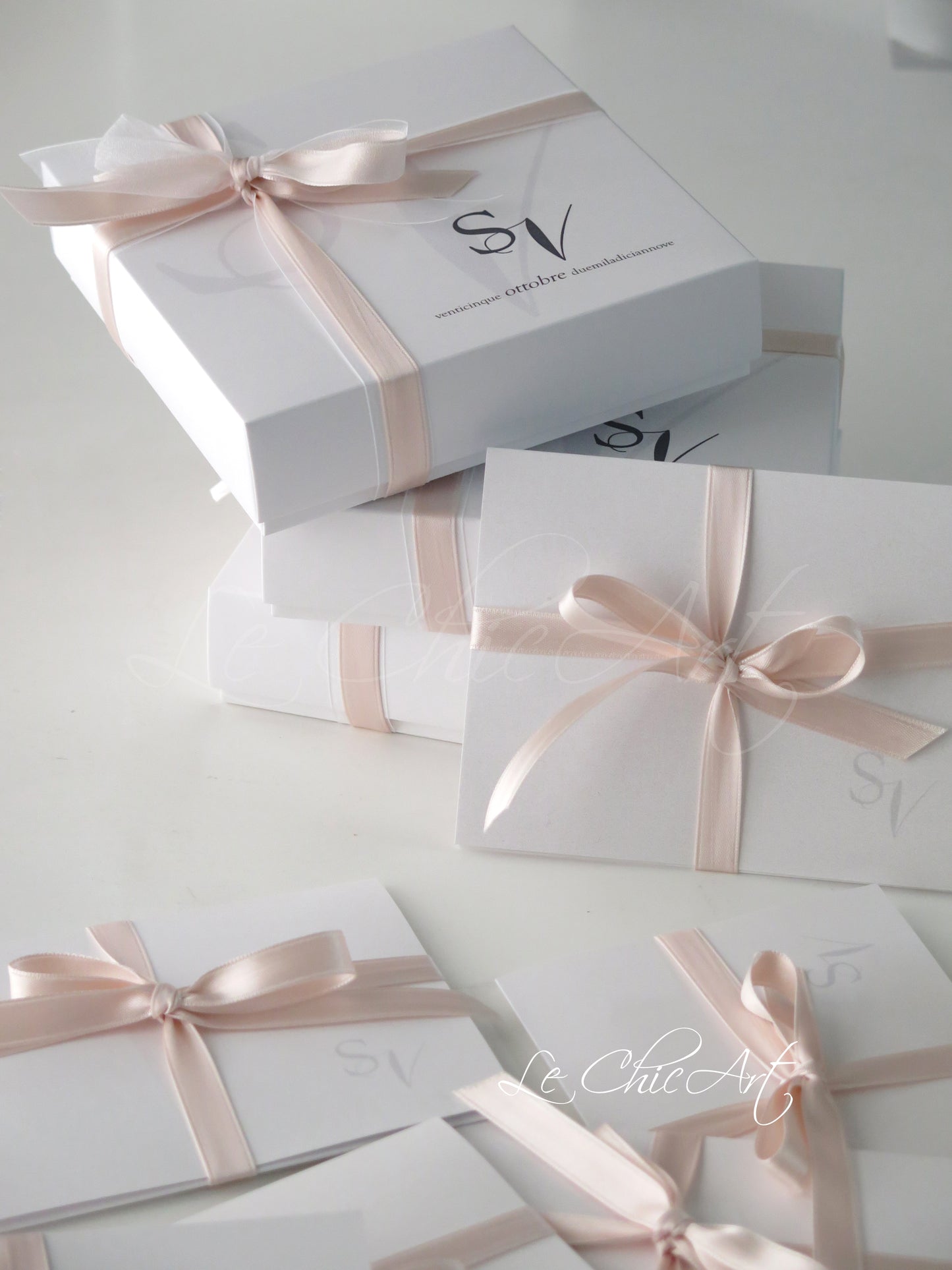 Bomboniera matrimonio elegante rosa cipria - Vista dall'alto scatola luxury 14x14cm con etichetta personalizzata iniziali sposi e nastro doppio raso premium
