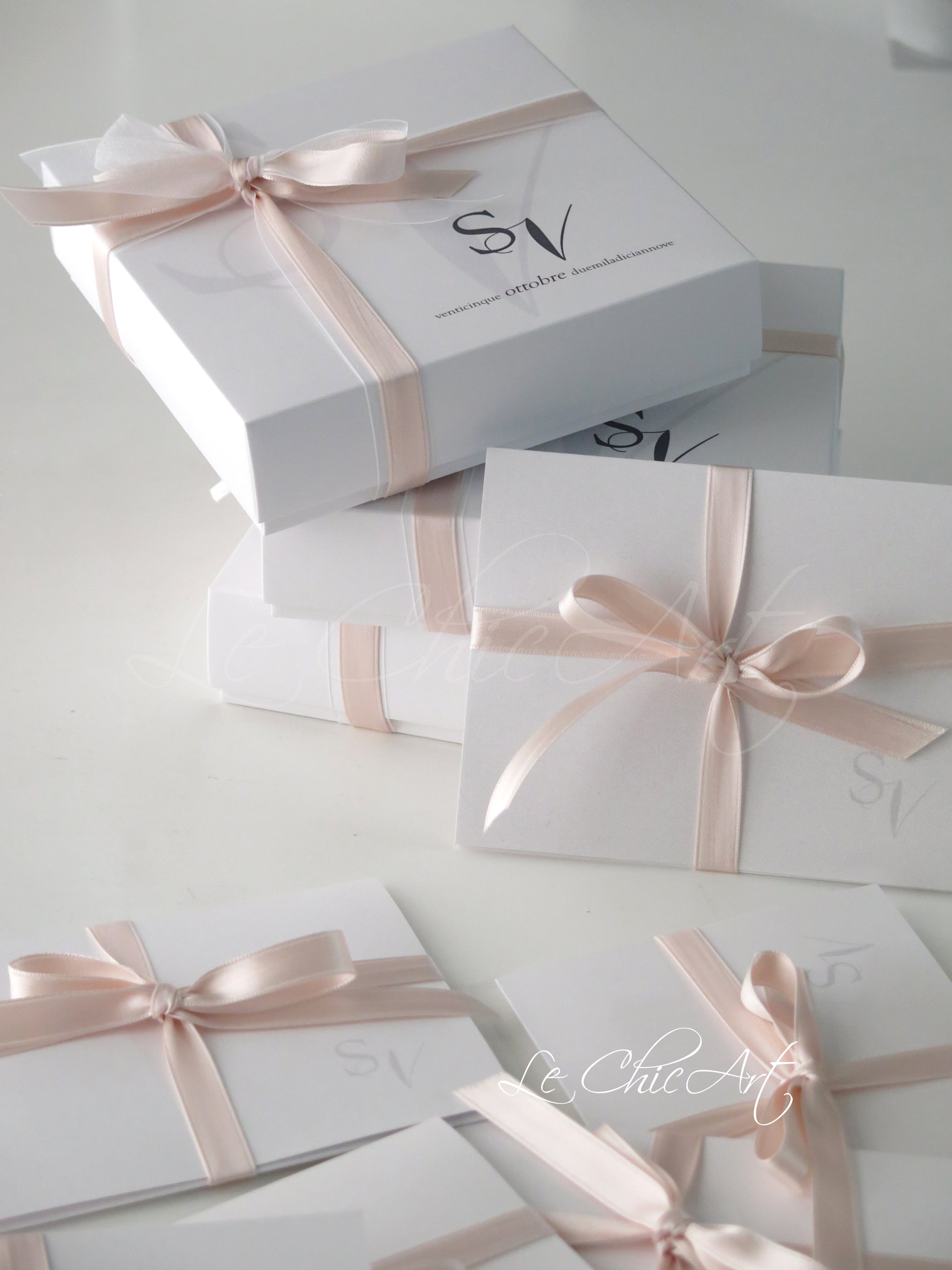 Bomboniera matrimonio elegante rosa cipria - Vista dall'alto scatola luxury 14x14cm con etichetta personalizzata iniziali sposi e nastro doppio raso premium
