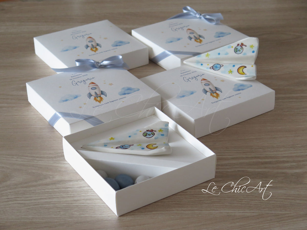 Bomboniere aeroplano dipinte a mano con confezioni personalizzate a tema razzo e nastri azzurro polvere.