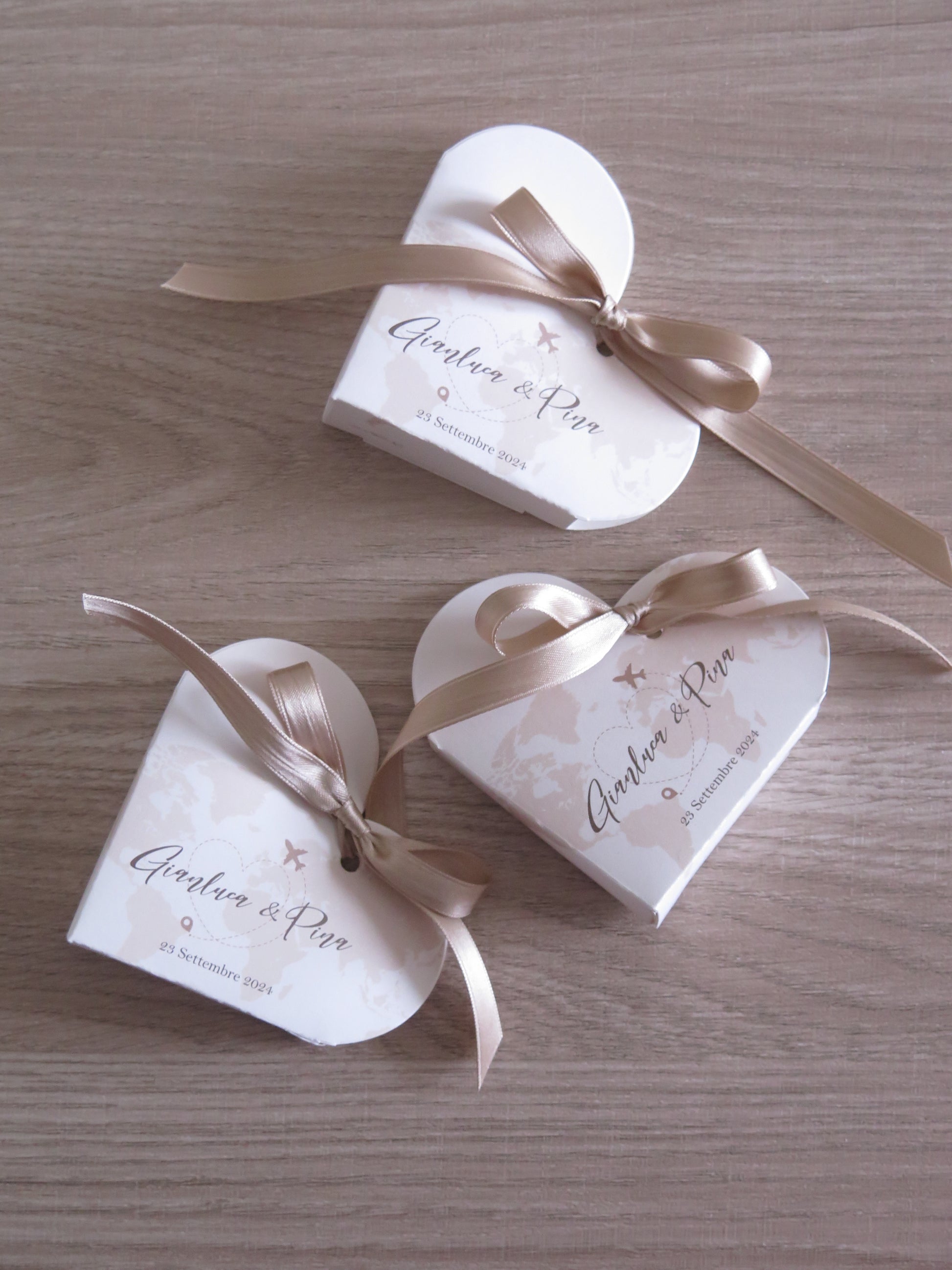 Dettaglio scatolina cuore tema viaggi aperta con confetti per promessa matrimonio Made in Italy