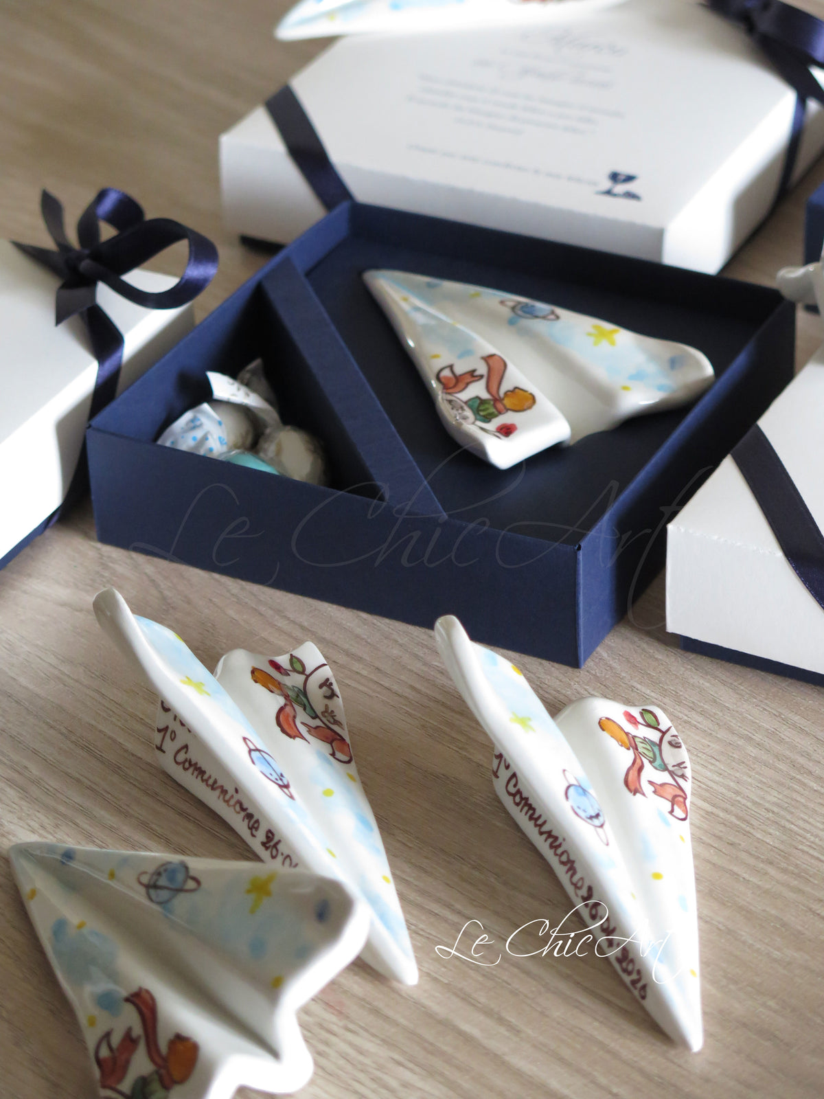 Aeroplani in ceramica dipinti a mano con Piccolo Principe, volpe, rosa e stelle, con scatola blu notte, confetti incartati singolarmente e nastro coordinato.