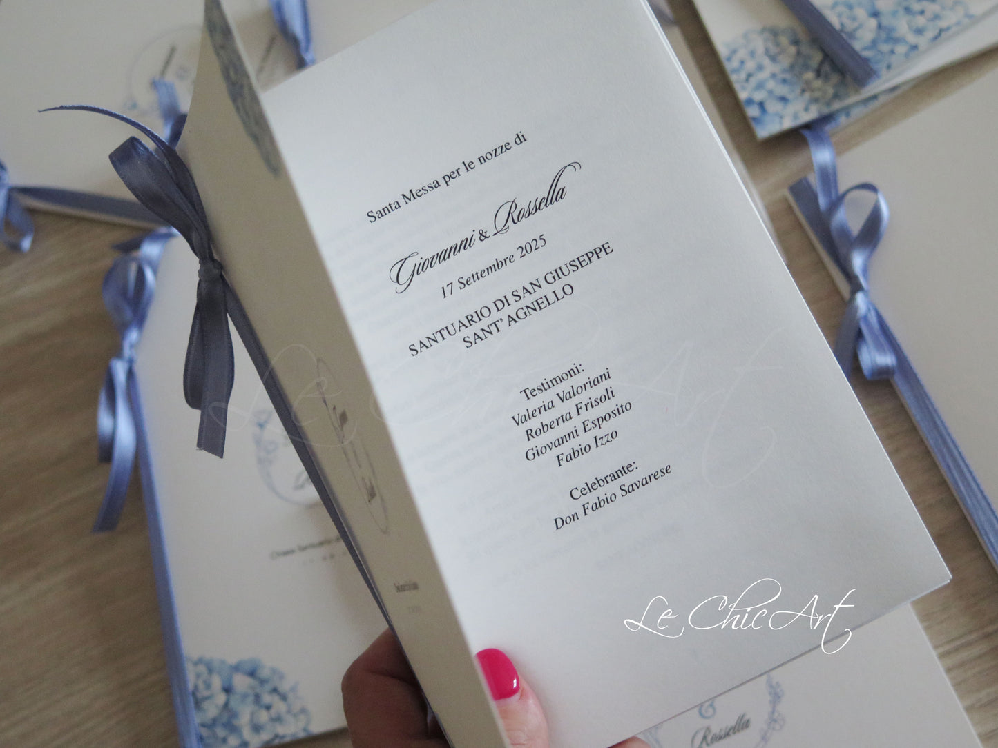 Dettaglio libretto messa matrimonio con ortensie azzurro avio e nastro carta da zucchero, cerimonia chiesa elegante con logo Le ChicArt