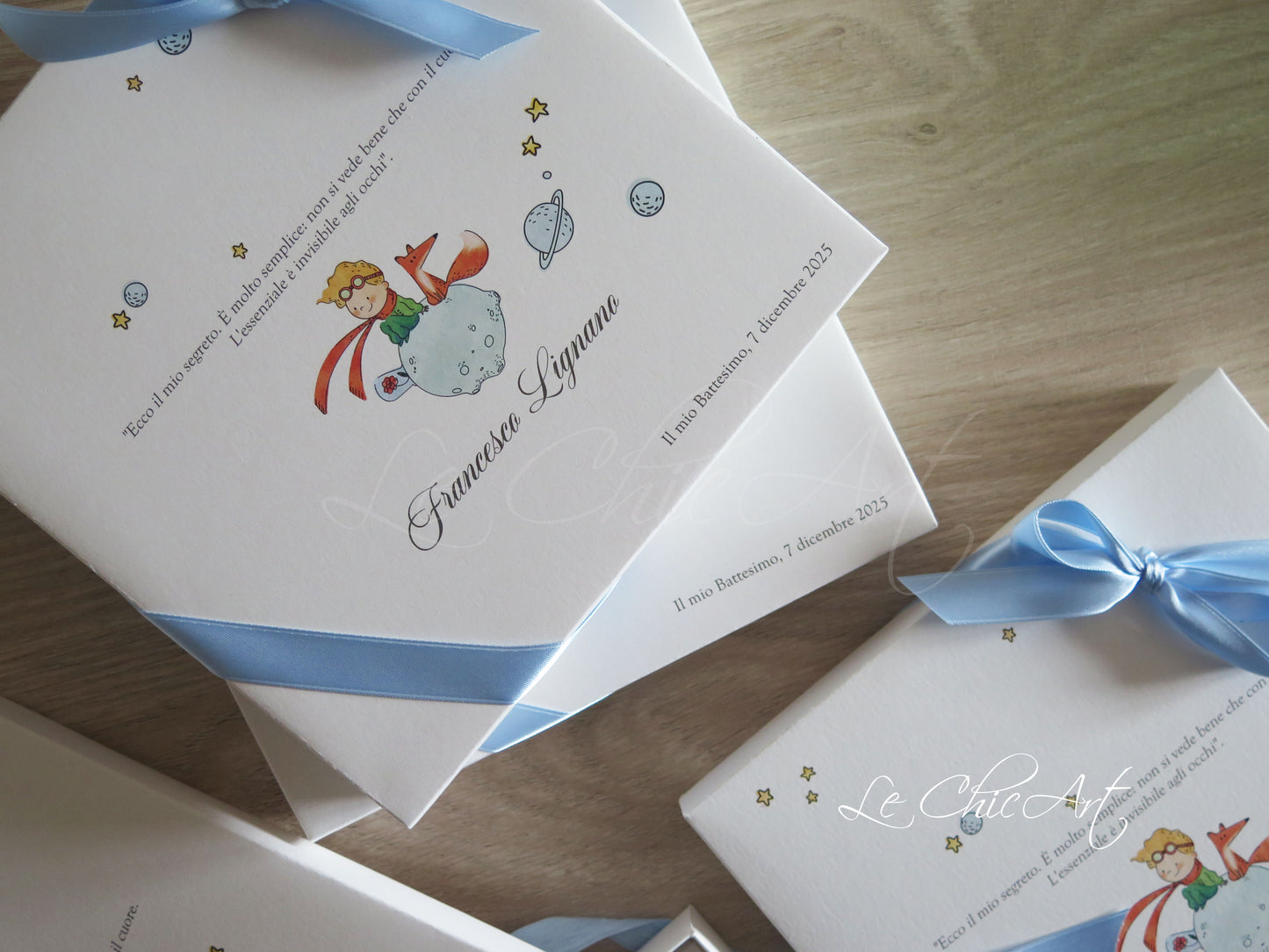 Dettaglio bomboniera libro Il Piccolo Principe in cartoncino nastro azzurro con volpe e pianeti e citazione celebre - bomboniere battesimo artigianali