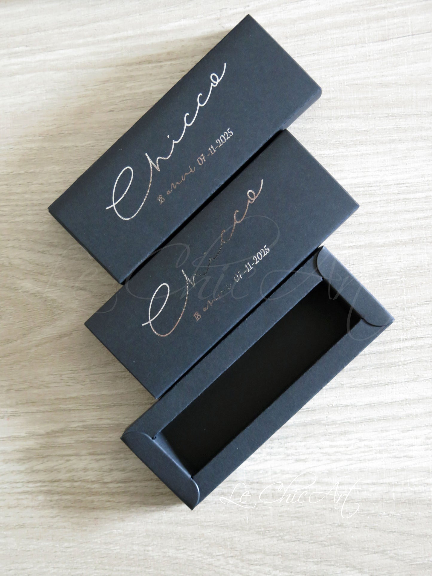 Scatola porta confetti nera aperta con stampa argento lucido contenente confetti argentati, sistema a sfilo 12x4x2cm per bomboniere eleganti diciottesimo