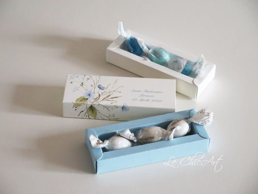 Scatola porta confetti battesimo premium con delicati fiori campestri azzurri su fondo bianco, formato mini sfilo 12x4x2cm per cerimonie eleganti
