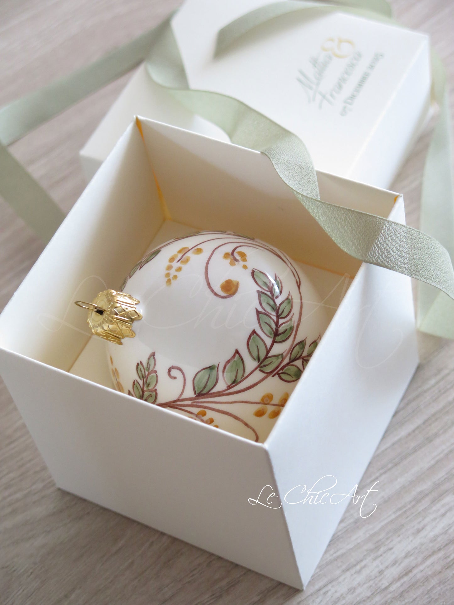 Dettaglio decorazione floreale dipinta a mano palla ceramica bianca bomboniera matrimonio verde salvia artigianale italiana premium