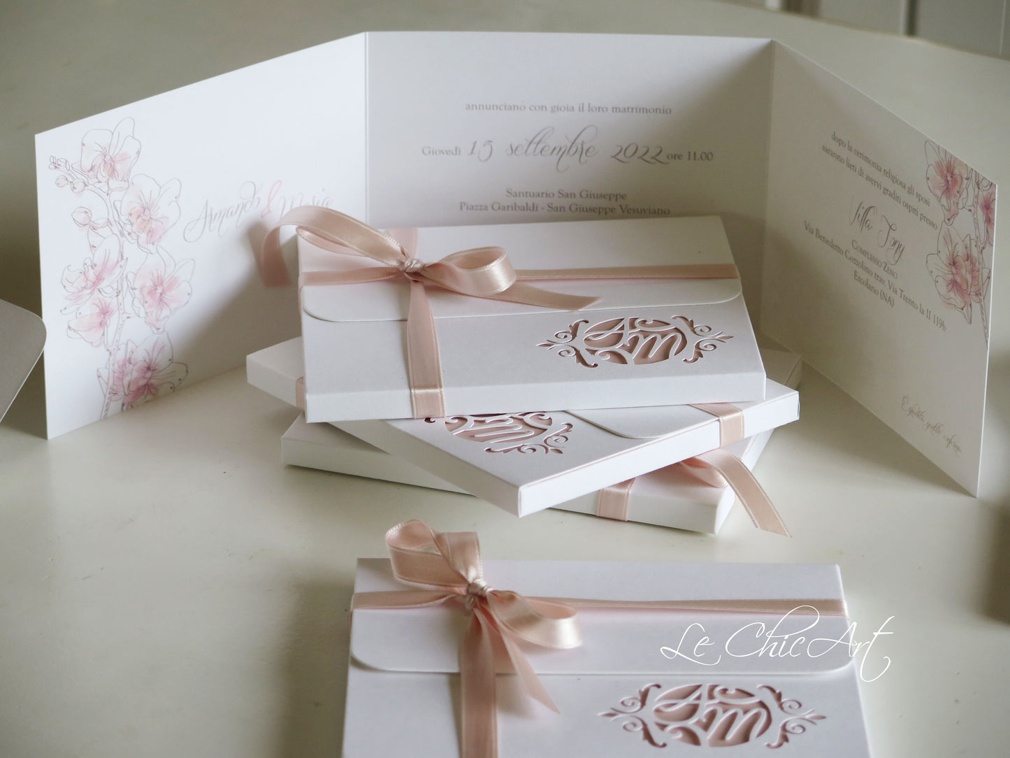 Dettaglio intaglio laser orchidea personalizzato su partecipazione matrimonio rosa cipria