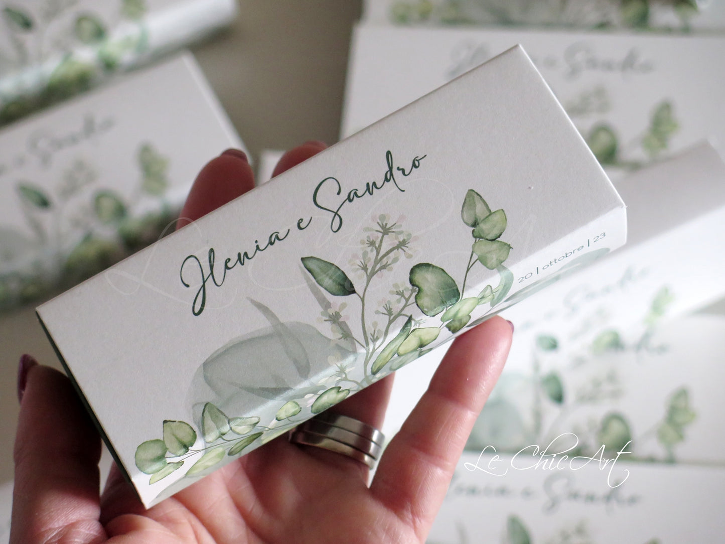 Set scatole bomboniera eucalipto verde salvia con data sul bordo, design botanico elegante già montate per promessa matrimonio - dettaglio composizione