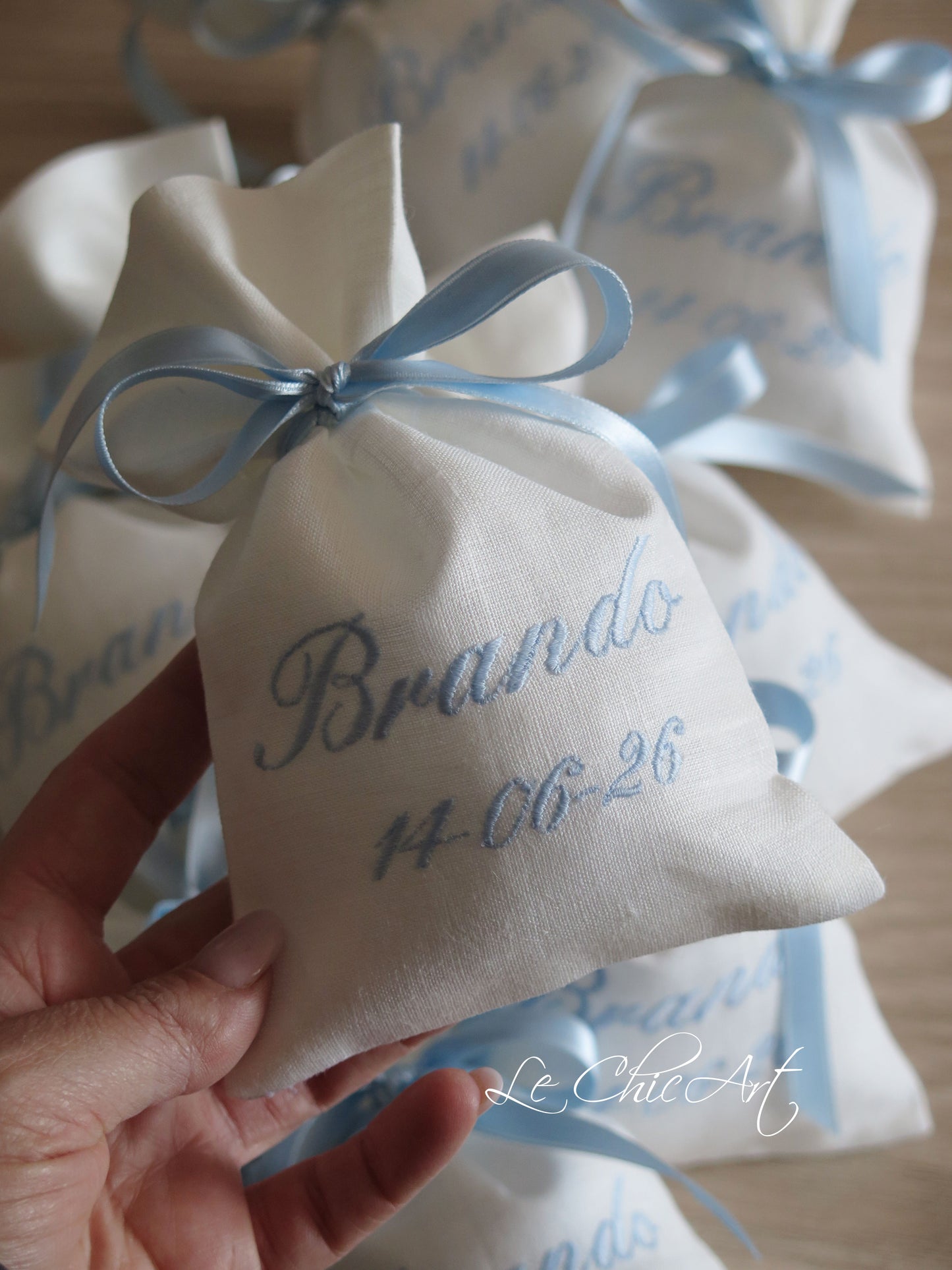 Set sacchetti portaconfetti sartoriali lino bianco ricamo nome e data azzurro polvere con nastro doppio raso azzurro, bomboniere battesimo personalizzate Made in Italy