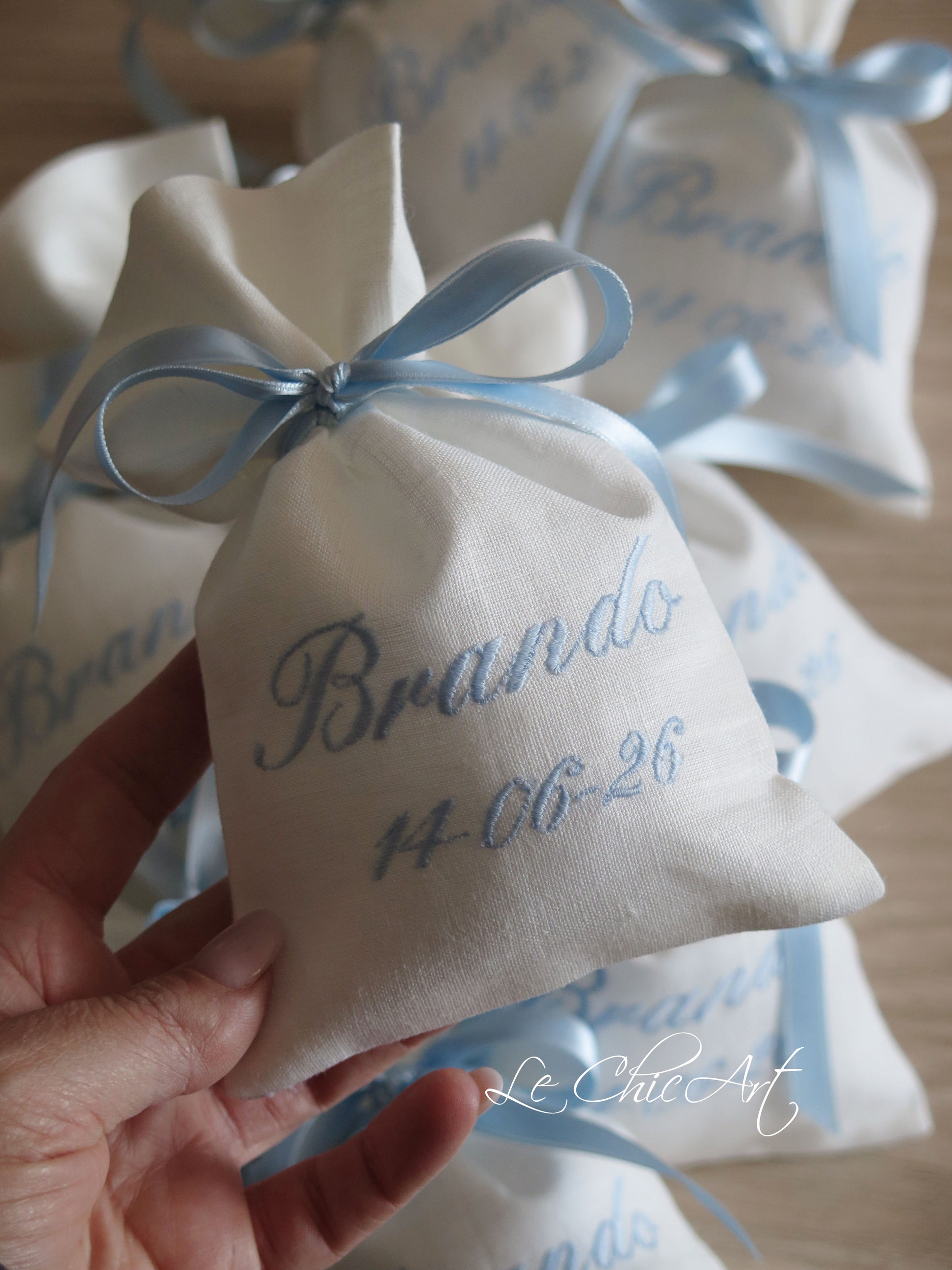 Set sacchetti portaconfetti sartoriali lino bianco ricamo nome e data azzurro polvere con nastro doppio raso azzurro, bomboniere battesimo personalizzate Made in Italy